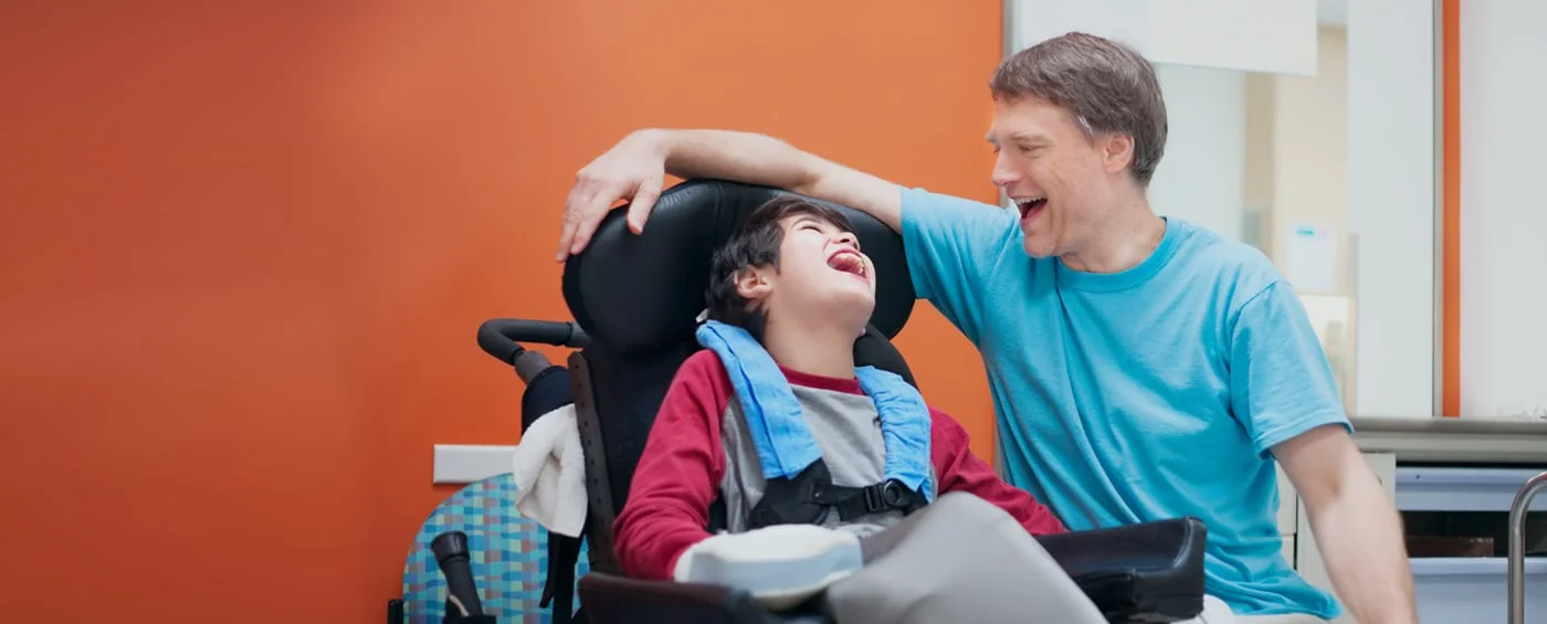 A child smiling with a parent during stem cell rehabilitation