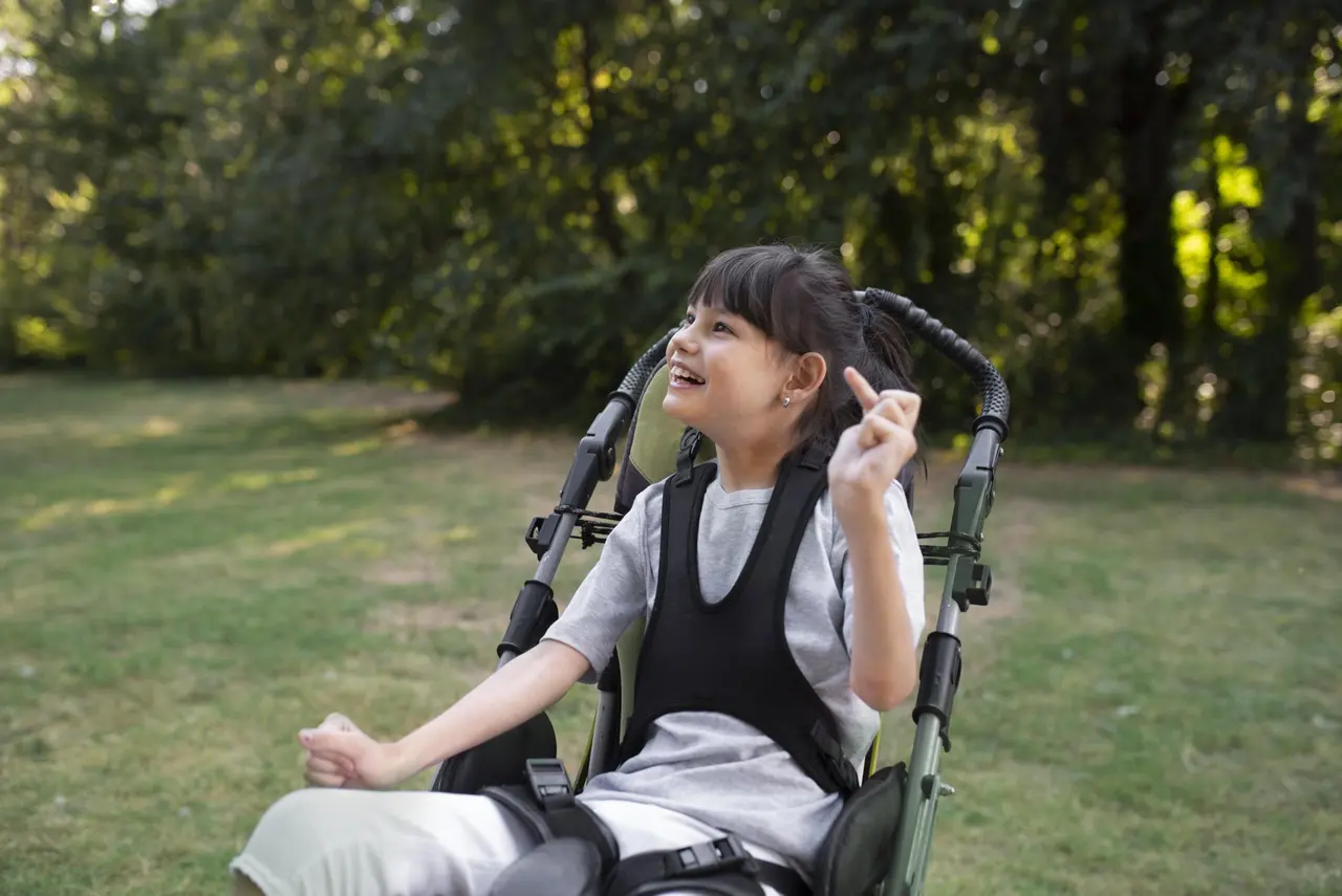 Young happy girl with cerebral palsy in wheelchair.